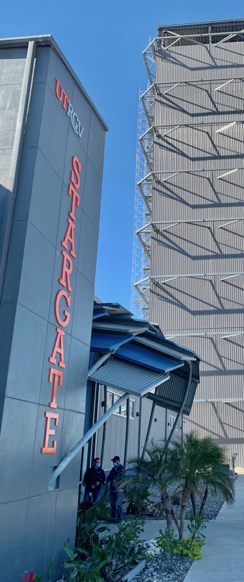 Entrance and signage for The University of Texas Rio Grande Valley's STARGATE facility at the SpaceX South Texas Launch Site near Brownsville, Texas. The entrance, seen at an angle with the Starbase High Bay standing behind it, is shaped like dragon